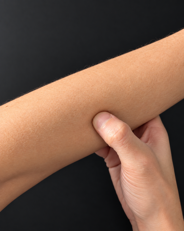 Opposite hand holding around the forearm with the thumb set against it.