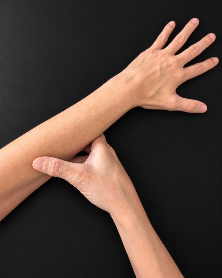 Working hand open with fingers extended above the opposite hand at the forearm.